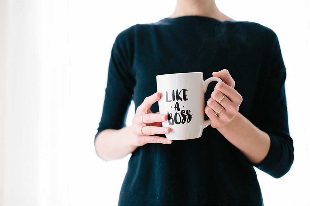 Woman holding a mug that says "Like a boss"